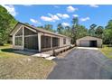 Charming home features a screened porch, two-car detached garage and a long paved driveway at 40325 Emeralda Island Rd, Leesburg, FL 34788