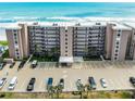 Exterior view of condominium complex with palm trees, parking, and ocean views at 4435 S Atlantic Ave # 114, Ponce Inlet, FL 32127