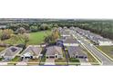 Areal view of the residence within a residential neighborhood surrounded by green spaces and mature trees at 488 Avila Pl, Howey In The Hills, FL 34737