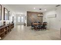 Light and bright dining area with modern decor, stylish lighting, and access to the entryway at 488 Avila Pl, Howey In The Hills, FL 34737