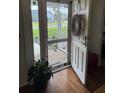 Inviting front door with a decorative wreath, wood floors, and a glimpse of the well-maintained front yard at 4941 Tradition Dr, Lakeland, FL 33812