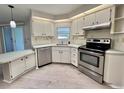 Well-equipped kitchen features stainless steel appliances, white cabinets, and ample counter space at 504 Hawthorne Blvd, Leesburg, FL 34748