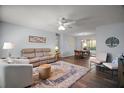 Bright living room featuring hardwood floors, neutral-colored walls, ceiling fan, and comfortable seating arrangement at 517 San Pedro Dr, Lady Lake, FL 32159