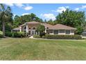 Charming home with a well-maintained lawn, mature trees, and a welcoming entryway at 5306 Greens Dr, Lady Lake, FL 32159