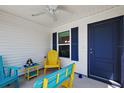 Inviting screened-in porch with bright blue and yellow furnishings and a ceiling fan for added comfort at 5817 Valente Ct, The Villages, FL 32163