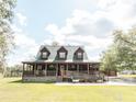 Inviting home with a wraparound porch, a beautiful lawn, and convenient ramp access at 8091 C 476B, Bushnell, FL 33513
