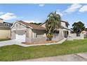 Lovely home with mature palm tree, stucco exterior, and manicured lawn at 830 Palm Harbor Ct, Leesburg, FL 34748