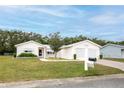 Inviting single-story home with a well-manicured lawn, two-car garage, and neatly placed mailbox at 10683 Se 174Th Loop, Summerfield, FL 34491