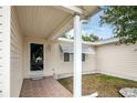Cozy front porch featuring a decorative storm door, awning, and textured tile flooring at 10683 Se 174Th Loop, Summerfield, FL 34491