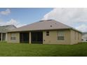 Home backyard featuring a large lawn and covered lanai at 13546 Biscayne Grove Ln, Grand Island, FL 32735