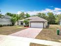 Attractive single-story house with a brick driveway and an attached two-car garage, perfect for Gathering living at 13546 Biscayne Grove Ln, Grand Island, FL 32735