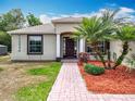 Welcoming front entrance with a dark wood door, decorative columns, and well-kept landscaping, offering curb appeal at 13546 Biscayne Grove Ln, Grand Island, FL 32735