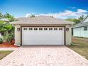 Spacious two-car garage featuring carriage doors and exterior lighting on a paved driveway, offering convenience at 13546 Biscayne Grove Ln, Grand Island, FL 32735