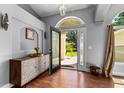 Warm and inviting foyer with hardwood flooring, a decorative cabinet and lots of natural light at 14421 Pine Cone Trl, Clermont, FL 34711