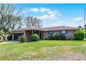 Inviting single-story brick home with blue shutters, an attached garage, and a lush green lawn at 16 Pine Run, Haines City, FL 33844