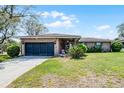 Attractive single-story brick house showcasing a well-manicured lawn, an attached garage, and a cozy front porch at 16 Pine Run, Haines City, FL 33844