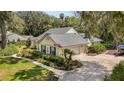 Attractive single-Gathering home with a lush, green lawn and a driveway leading to an attached garage and mature foliage at 16730 Beauclaire Ct, Tavares, FL 32778