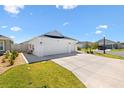 Bright white three car garage with large drive in front of a single story home at 1674 Cadorette Dr, The Villages, FL 34762