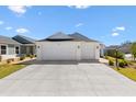 Wide three car garage on a single story home with a large concrete drive at 1674 Cadorette Dr, The Villages, FL 34762