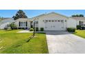 Beautiful one-story home with lush green lawn, a two-car garage, and a neatly maintained landscape at 17385 Se 76Th Champion Ave, The Villages, FL 32162