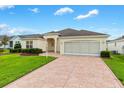 Beautiful one-story home with a stamped concrete driveway and lush landscaping at 2120 Callaway Dr, The Villages, FL 32162