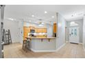 Well-lit kitchen featuring wood cabinets, granite countertops, and a breakfast bar at 2120 Callaway Dr, The Villages, FL 32162