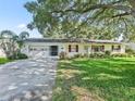 Traditional home with a well manicured lawn, attached garage and red window trim at 2401 Greenlaw Ct, Leesburg, FL 34788
