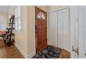 Inviting entryway featuring hardwood floors, a decorative rug, and convenient closet space for storage at 25541 Troon Ave, Sorrento, FL 32776