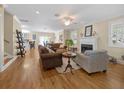 Open-concept living room featuring hardwood floors, a fireplace, and seamless access to the kitchen and dining area at 25541 Troon Ave, Sorrento, FL 32776