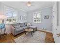 Cozy living room with natural light, hardwood floors, a comfortable couch, and a stylish area rug at 25541 Troon Ave, Sorrento, FL 32776