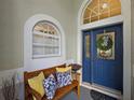 Cozy front porch with a bench and decorative blue door and transom window at 3584 Tropical Seas Loop, Tavares, FL 32778