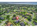 Beautiful aerial view of a residential area featuring lush greenery, a large lake, and houses with well-kept lawns at 39653 Grove Hts, Lady Lake, FL 32159