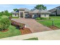 Attractive single-story home with an extended paver driveway, well-maintained landscaping and a welcoming front entrance at 39653 Grove Hts, Lady Lake, FL 32159