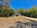 A quaint single-story home with a long driveway surrounded by mature trees at 40226 Palm St, Lady Lake, FL 32159