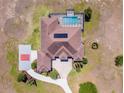 Aerial view of the property showcasing a private pool, tennis court, and well-maintained landscaping at 41522 Saddle Ridge Ln, Weirsdale, FL 32195