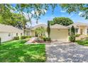 Inviting single-story home with a lush front lawn, mature landscaping, and a convenient two-car garage at 4167 Capland Ave, Clermont, FL 34711