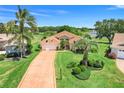 Aerial view of a well maintained one-story home with a long driveway, lush lawn, and tropical landscaping at 4720 Summerbridge Cir, Leesburg, FL 34748