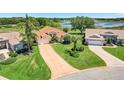 Aerial view of a well-maintained one-story home with manicured landscaping and a long driveway at 4720 Summerbridge Cir, Leesburg, FL 34748