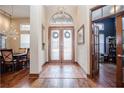 Inviting foyer features a decorative front door with tile flooring and natural light, complemented by wood floors at 5495 County Road 125, Wildwood, FL 34785