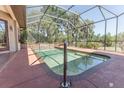 The screened-in, in-ground pool offers a refreshing escape, complemented by tile accents and a relaxing ambiance at 5495 County Road 125, Wildwood, FL 34785