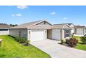 Inviting single-story home with a concrete driveway and a two car garage at 6471 Ecoff Pl, The Villages, FL 34762