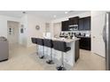 Eat-in kitchen features an island with seating, modern lighting, and stainless appliances at 8024 Oak Shadow Ct, Davenport, FL 33837