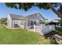 Cozy backyard featuring a patio, white picket fence, and lush green lawn at 909 Cajon Ct, The Villages, FL 32159