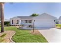 Charming single-story home with a well-manicured lawn and a two-car garage at 909 Cajon Ct, The Villages, FL 32159