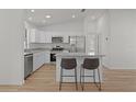 Modern kitchen with stainless steel appliances, breakfast bar, and white cabinets at 909 Cajon Ct, The Villages, FL 32159