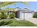 Attractive single-story home boasting a two-car garage, lush lawn, and appealing curb appeal at 1633 Manserra St, The Villages, FL 32163