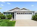 Lovely single-story home with a spacious two-car garage, green lawn, and well-maintained landscaping at 1633 Manserra St, The Villages, FL 32163