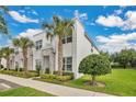 Contemporary townhomes featuring modern design, lush lawns, and palm tree landscaping at 17519 Hidden Forest Dr, Clermont, FL 34714