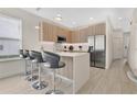 Modern kitchen featuring an island with bar seating and stainless steel appliances at 17519 Hidden Forest Dr, Clermont, FL 34714