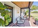 Charming front porch with comfortable seating, decorative plants, and wood accents, perfect for relaxing at 602 Cr 489, Lake Panasoffkee, FL 33538
